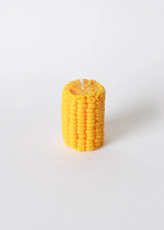 Yellow corn-shaped candle on a white background