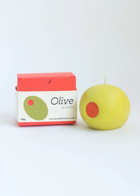 Green candle with red center next to a box labeled 'Olive de Nata' on a white background