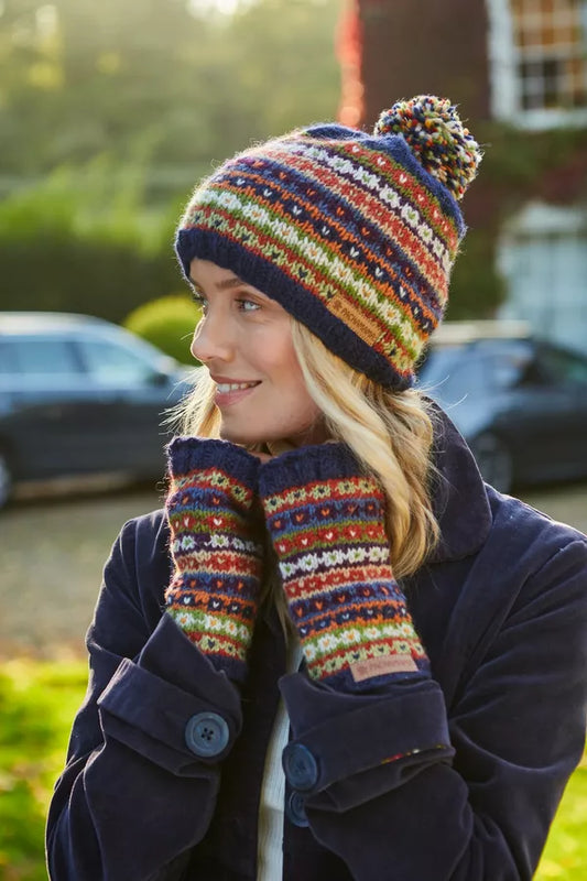 Person wearing a colorful striped knit hat and gloves outdoors