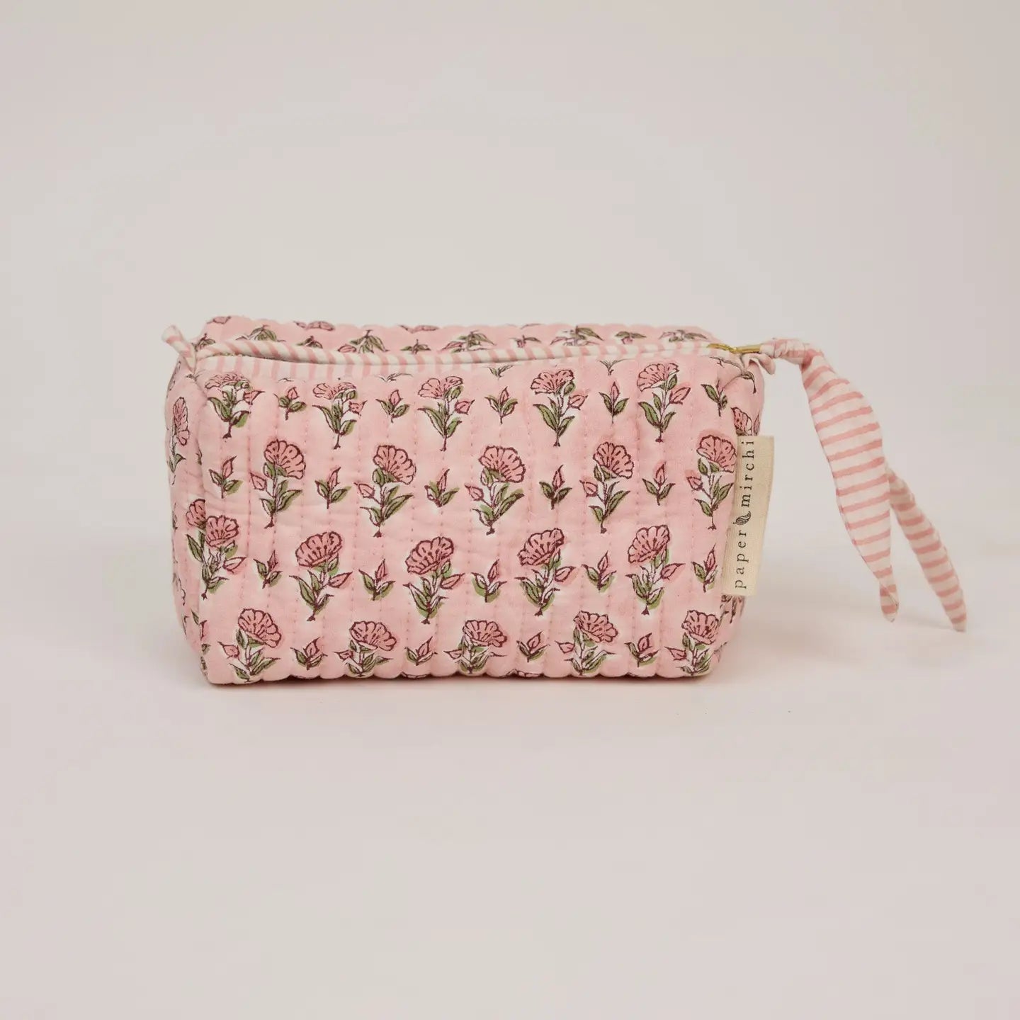 Pink floral pouch with striped handle on a light pink background