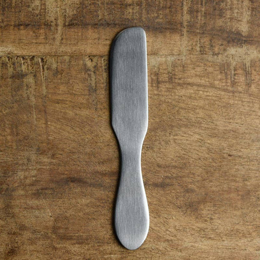 Metal butter knife on a wooden surface