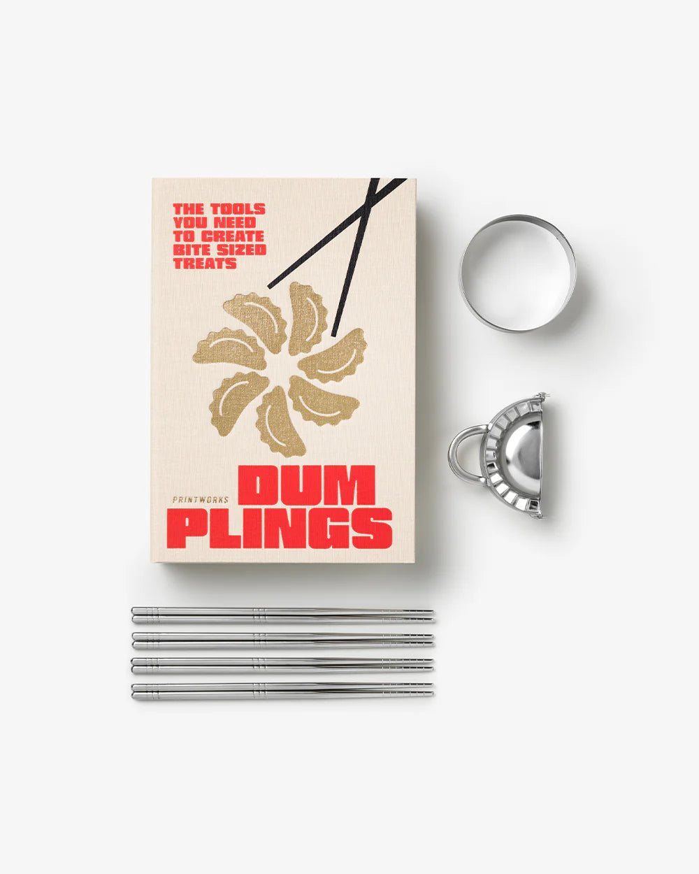 Dumpling making kit with box, metal tools, and straws on a white background