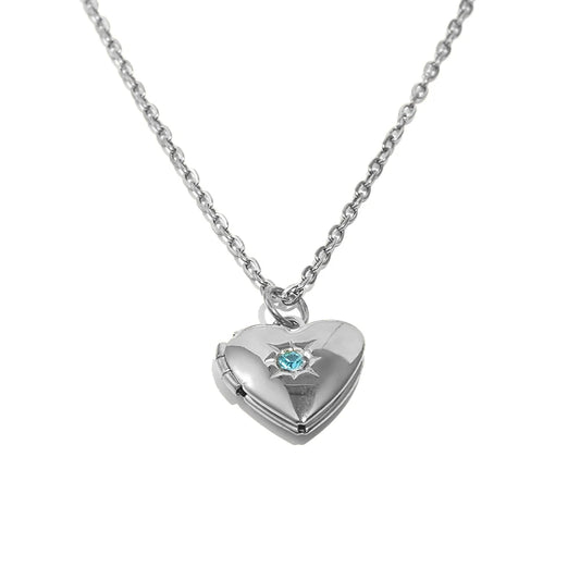 Silver heart-shaped locket with a blue gemstone on a white background
