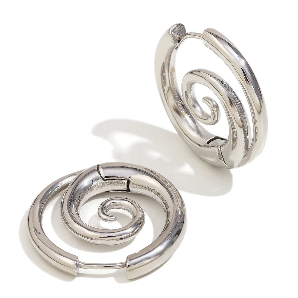 Silver spiral hoop earrings on a white background