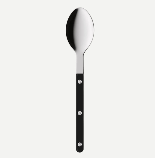 A modern kitchen spoon with a polished silver metal bowl and a sleek black handle secured by three silver rivets, shown against a light gray background.