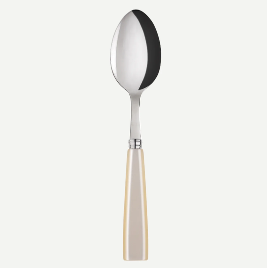 A polished stainless steel spoon with a cream-colored pearl like handle, centered against a light gray background.