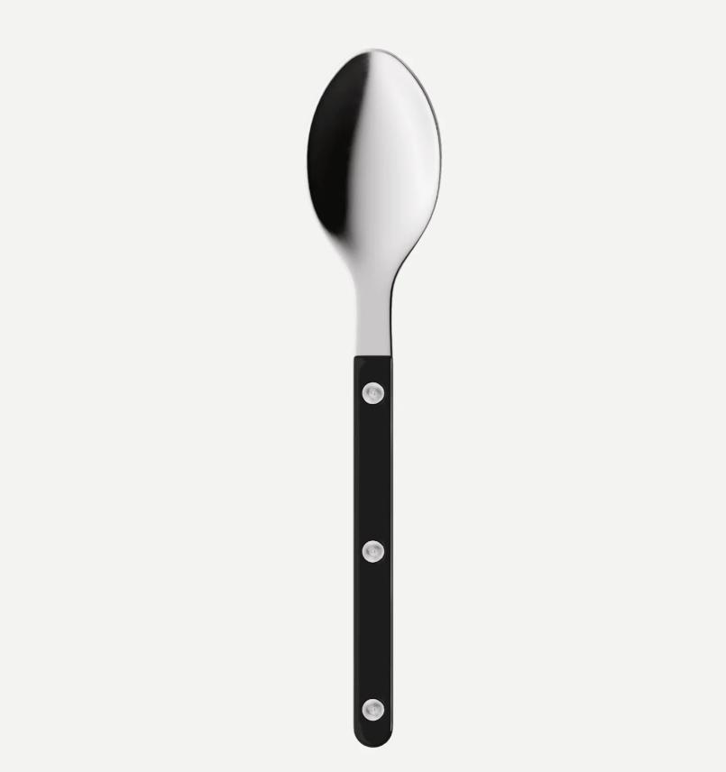 A modern stainless steel spoon with a black handle featuring three silver rivets, shown vertically against a light gray background.