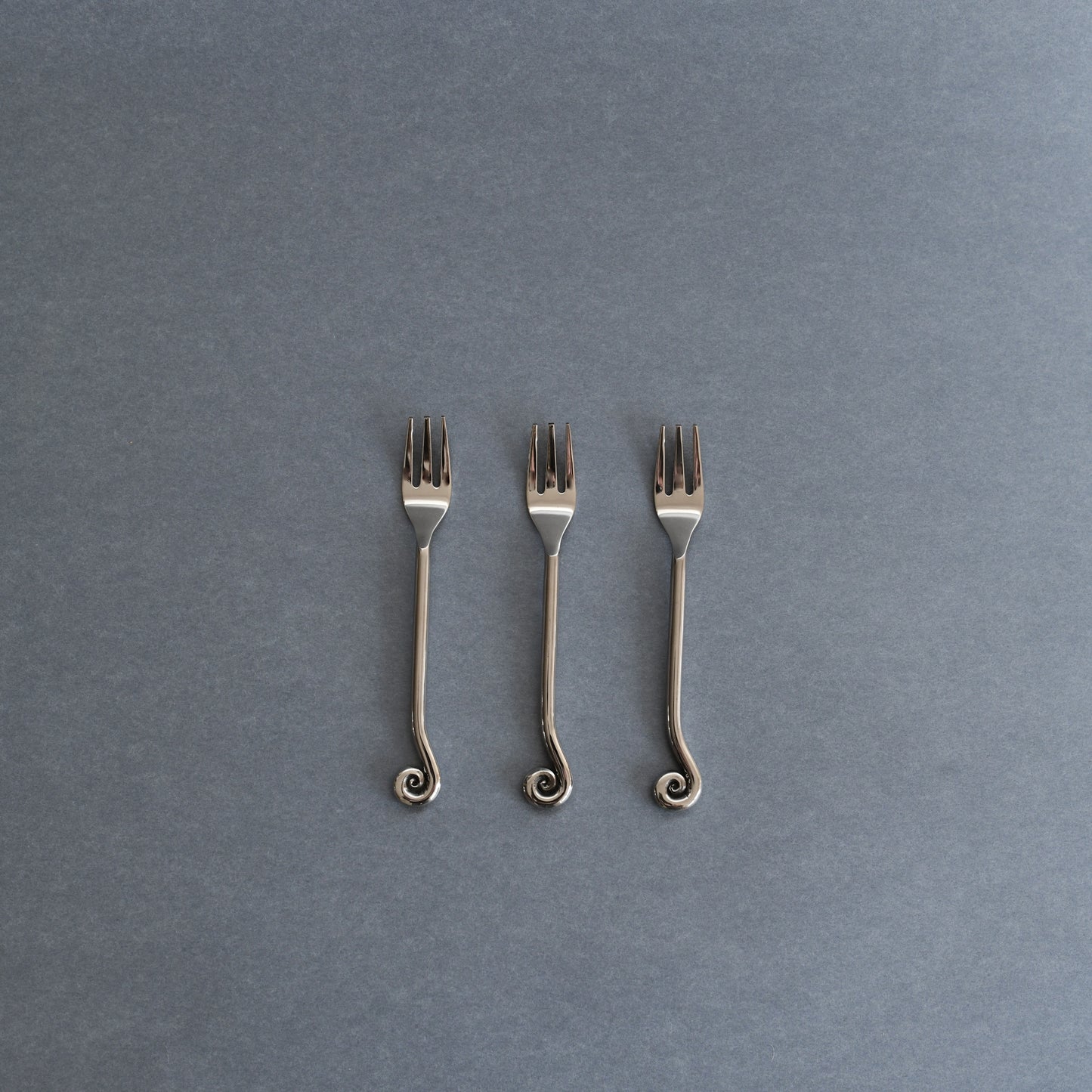 SOOS Atelier Mira Cake Fork set of 3 on a blue background 