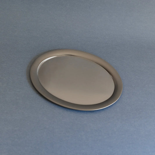 Oval silver tray on a gray background