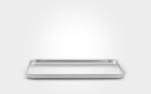 A rectangular stainless steel baking pan with raised rim and shallow depth, shown from a front angle on a light gray gradient background.