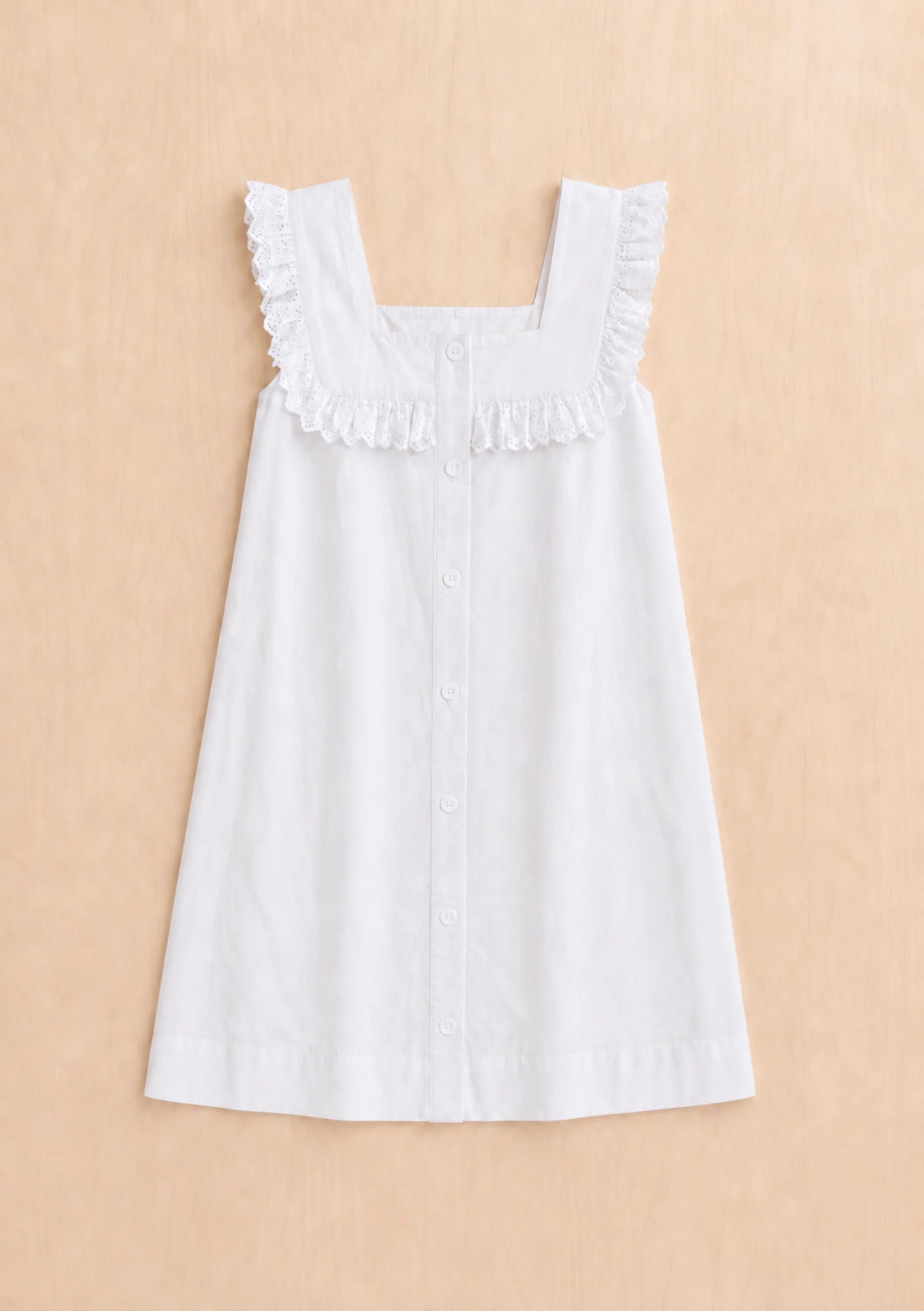 White dress with ruffled straps on a beige background