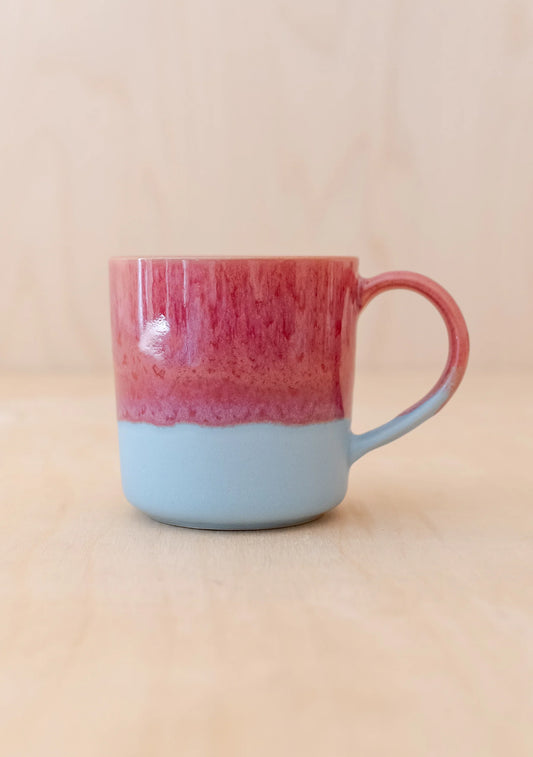 Mug with red top and blue bottom on a beige background