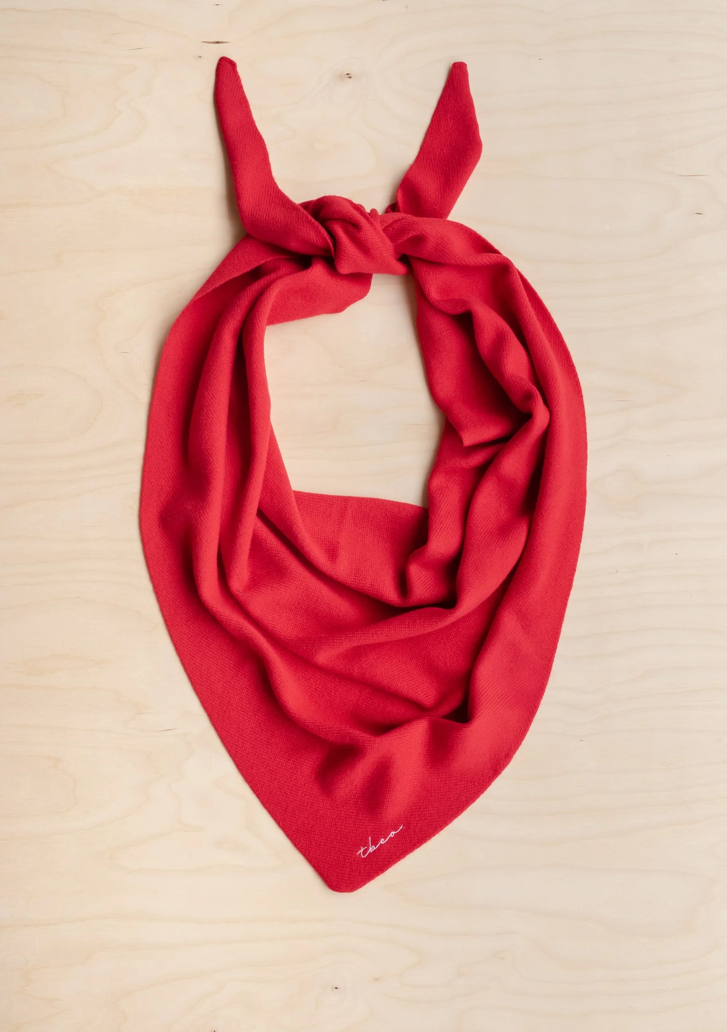Red scarf with a knot on a beige background