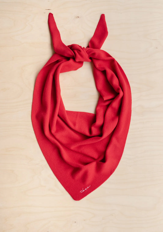 Red scarf with a knot on a beige background