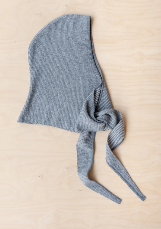 Grey wool hood/scarf on a beige background.