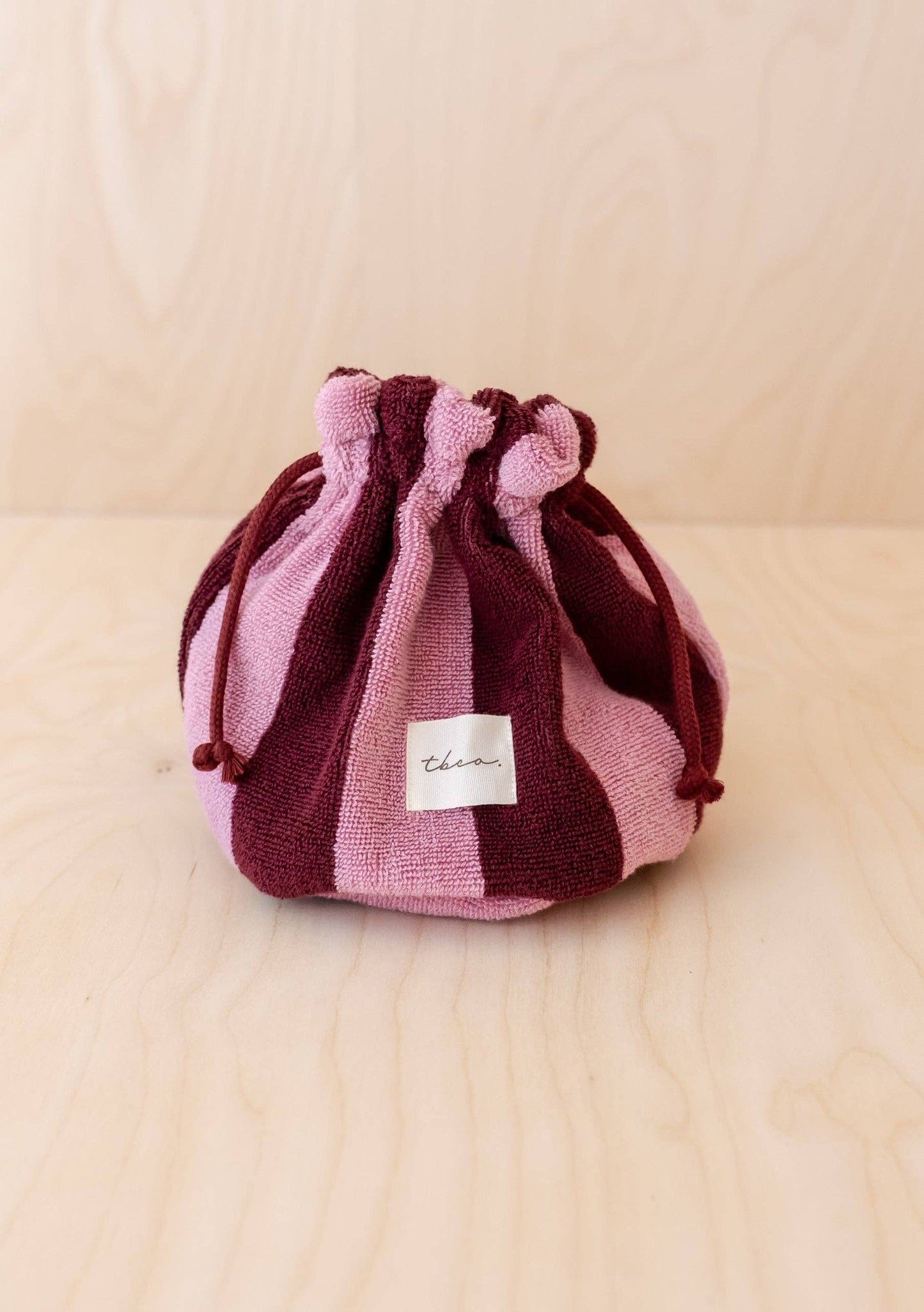 Striped drawstring bag on a beige background