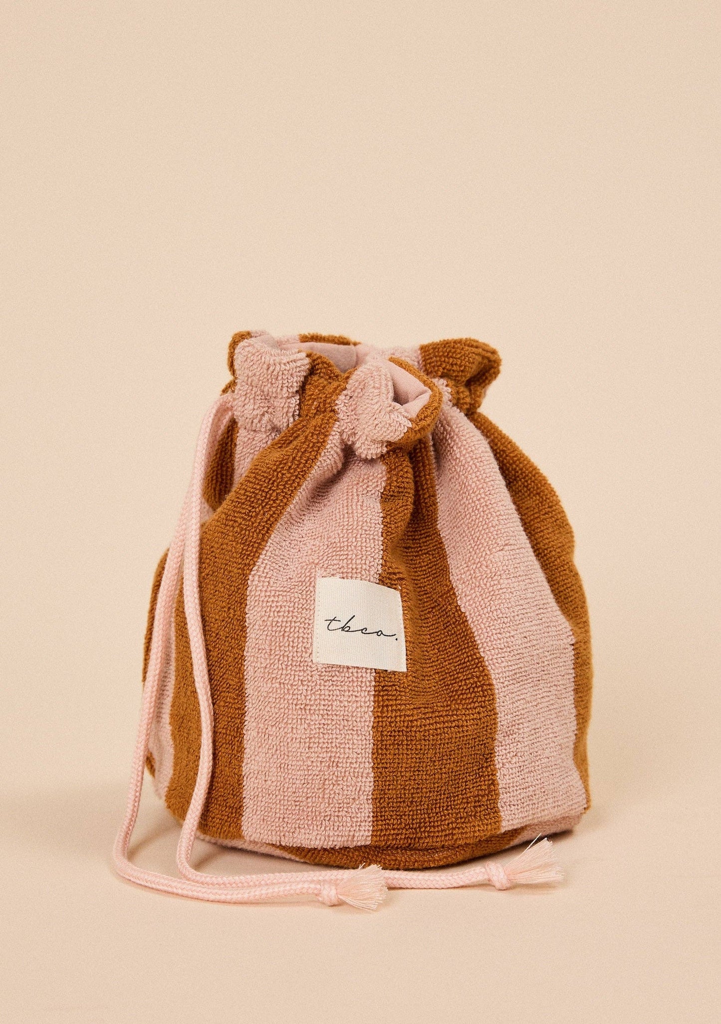 TBCo Terry Cotton Wash Bag in in Honeycomb Stripe colourway on a beige background 