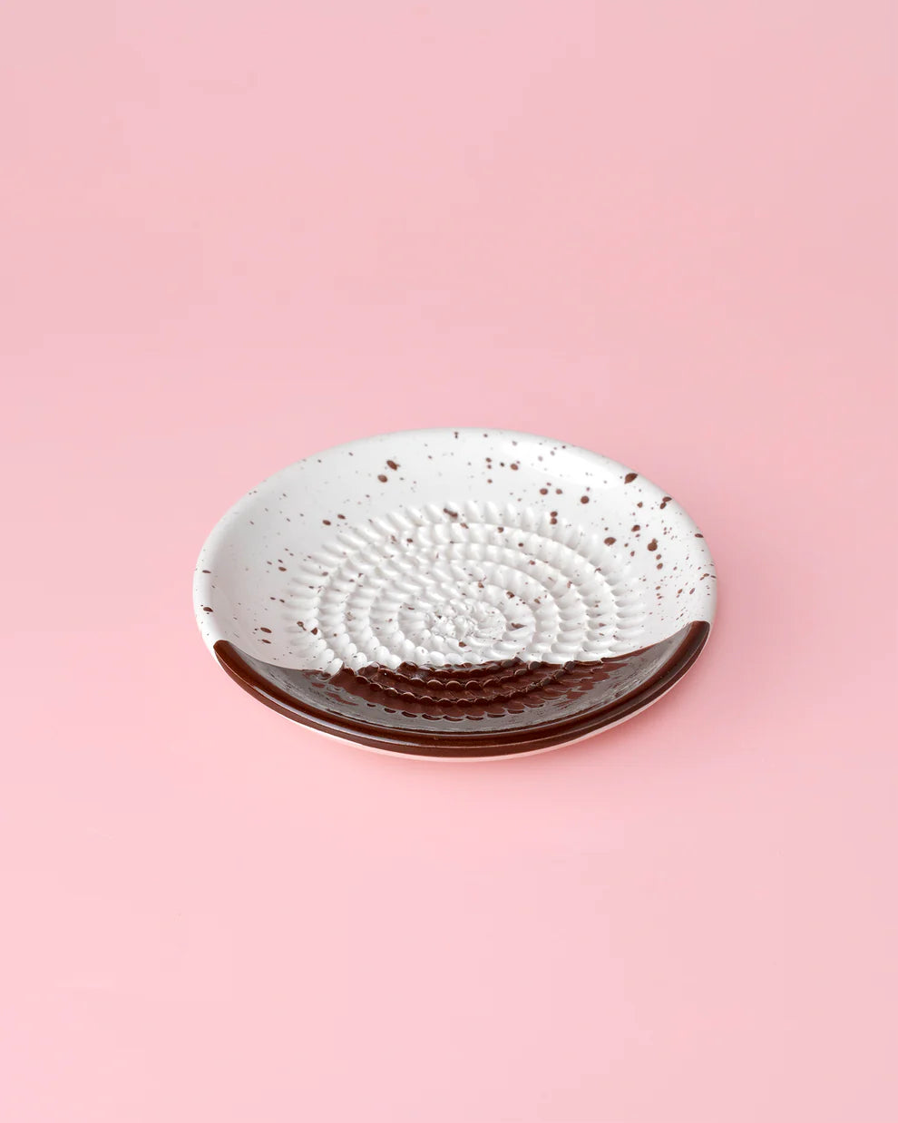 Ceramic plate with a textured design on a pink background