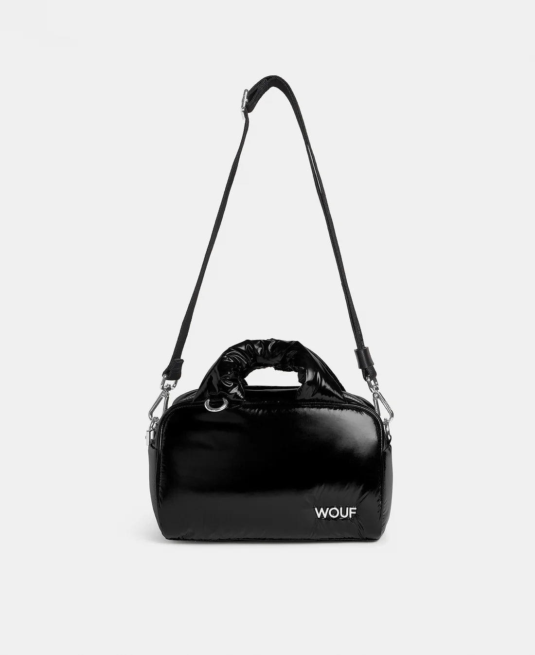 Black handbag with shoulder strap on a light gray background