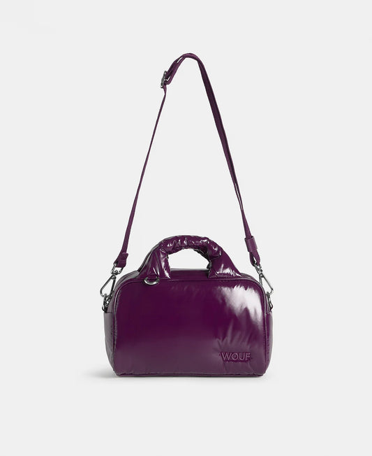 Purple handbag with a visible brand logo on a light gray background