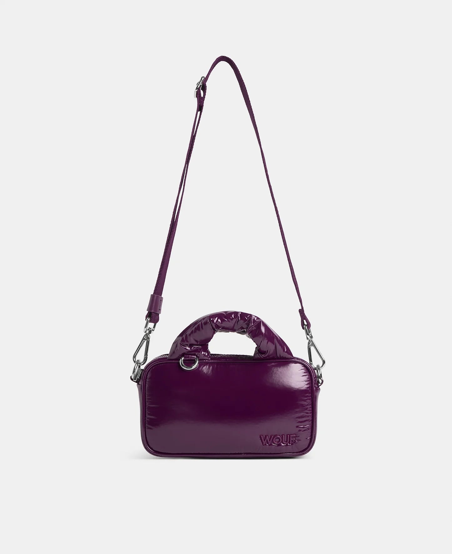 A glossy deep purple top-handle shoulder bag with a matching adjustable shoulder strap, silver-tone hardware, and a debossed 'WOUF' logo on the front, shown against a light gray background.