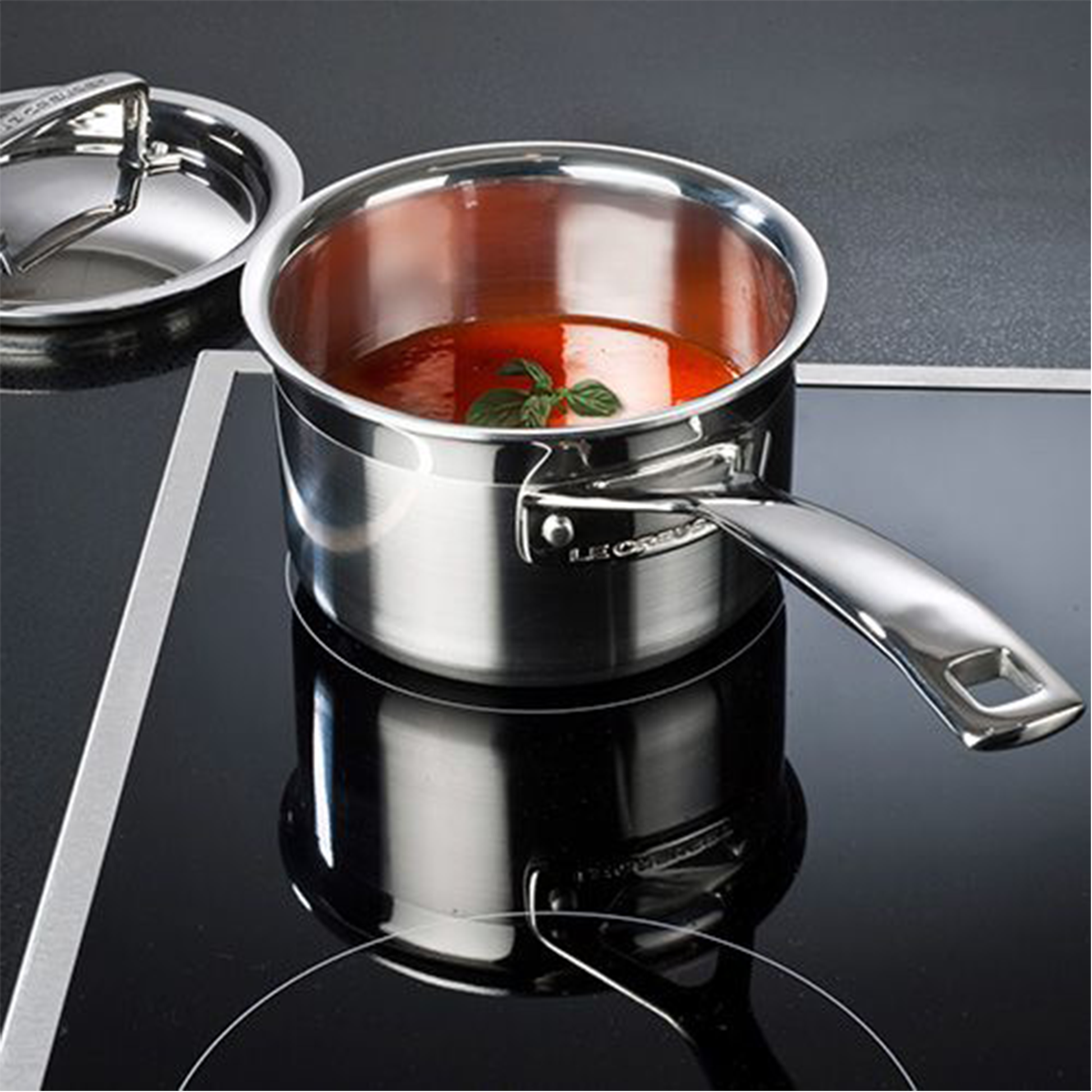 the saucepan being used to cook tomato soup