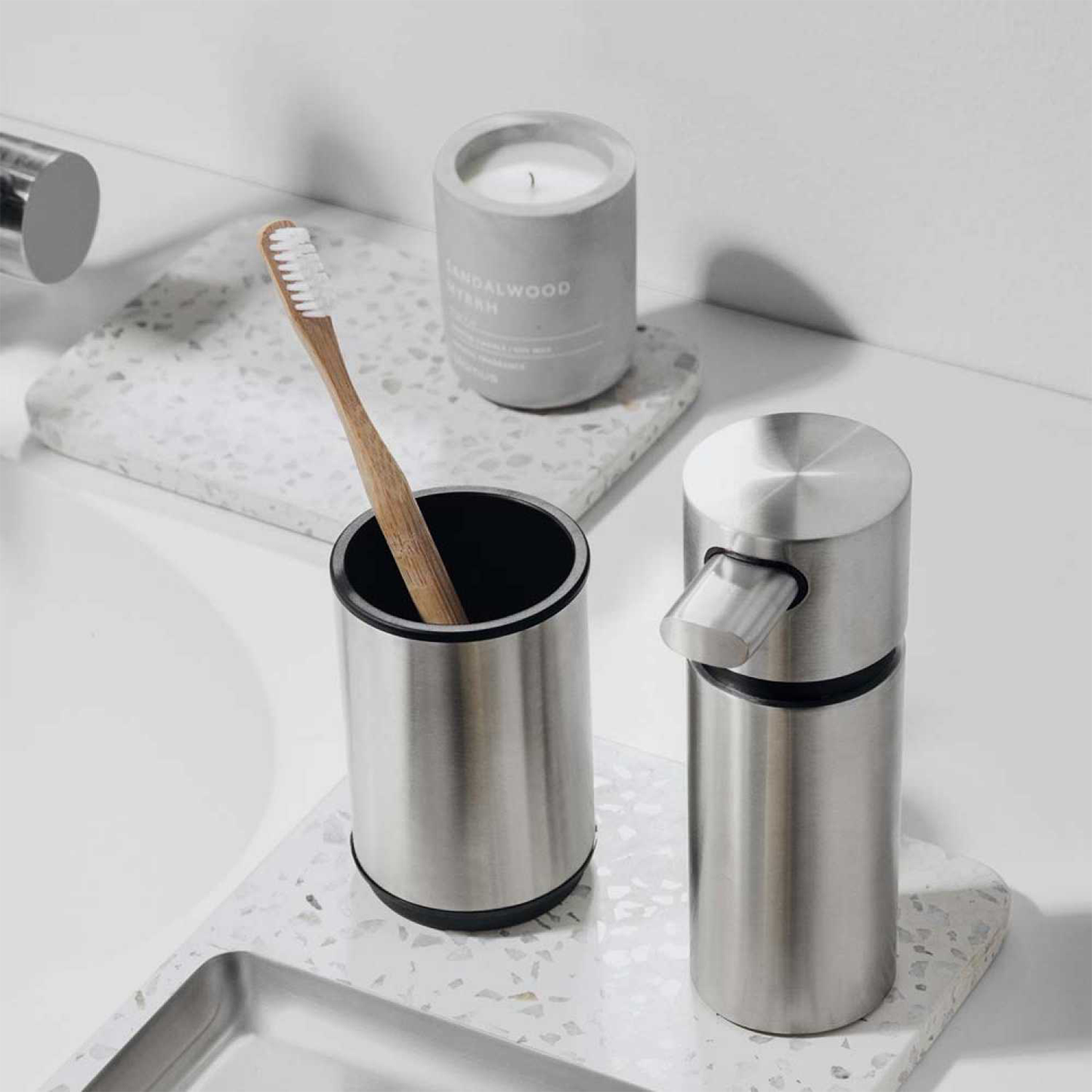 a sandlewood and myrrh candle displayed on a bathroom counter