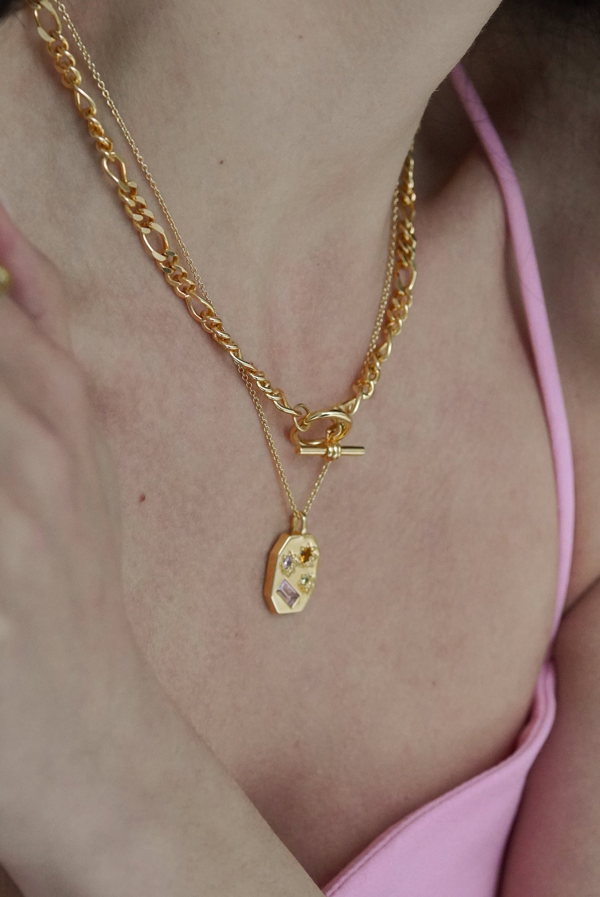 necklace shown in gold on a model