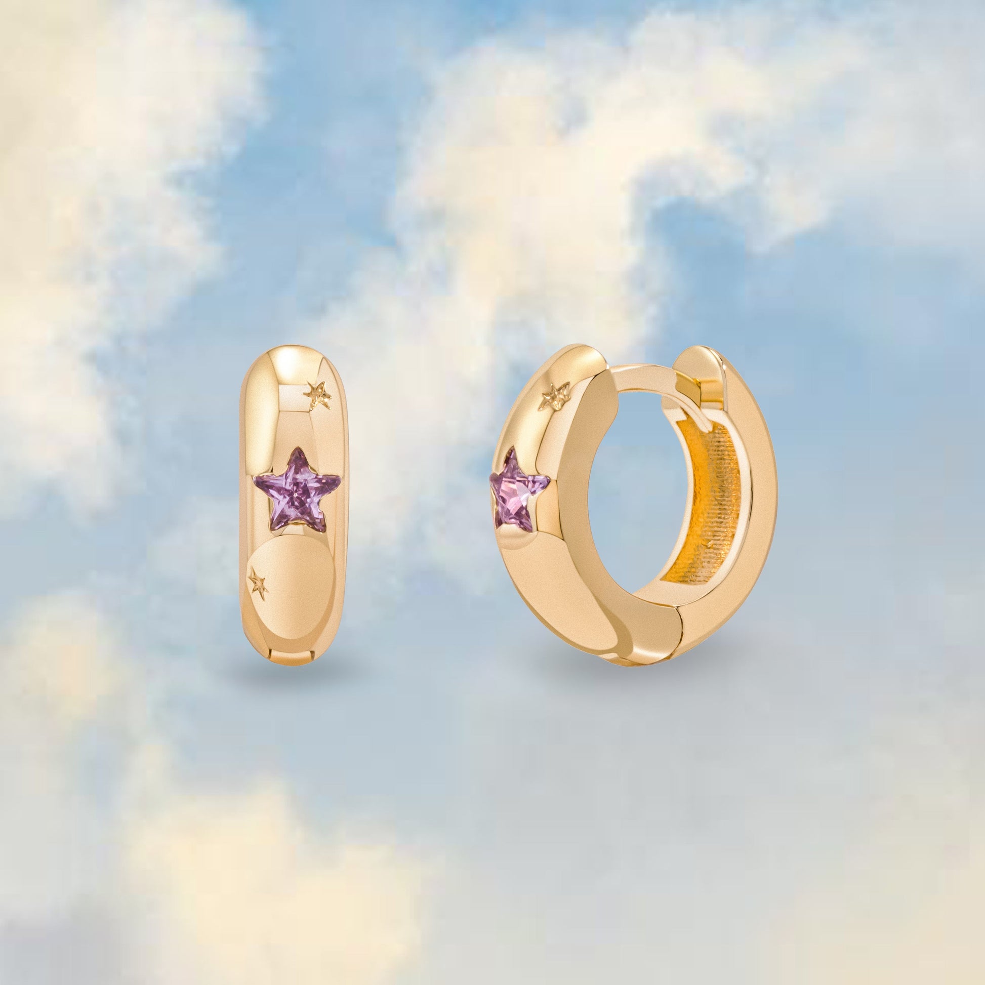 chunky gold huggie hoops with star shaped pink gemstone on a cloud background 