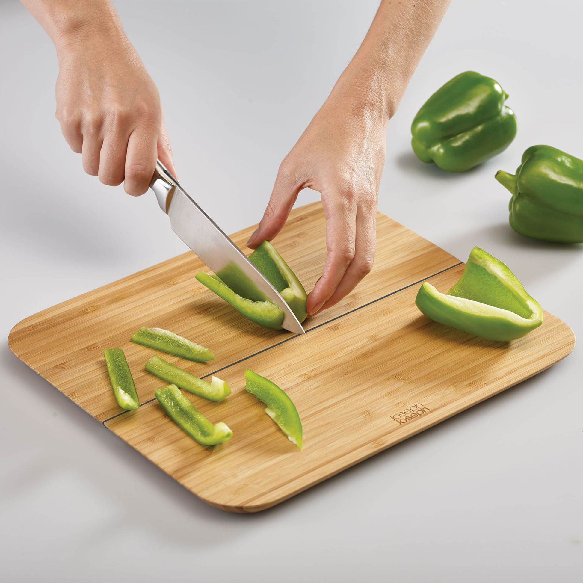 a person chopping a green pepper on the board