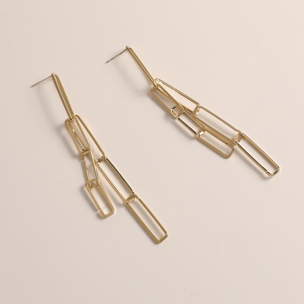 gold drop link dangly earrings on a pale pink background