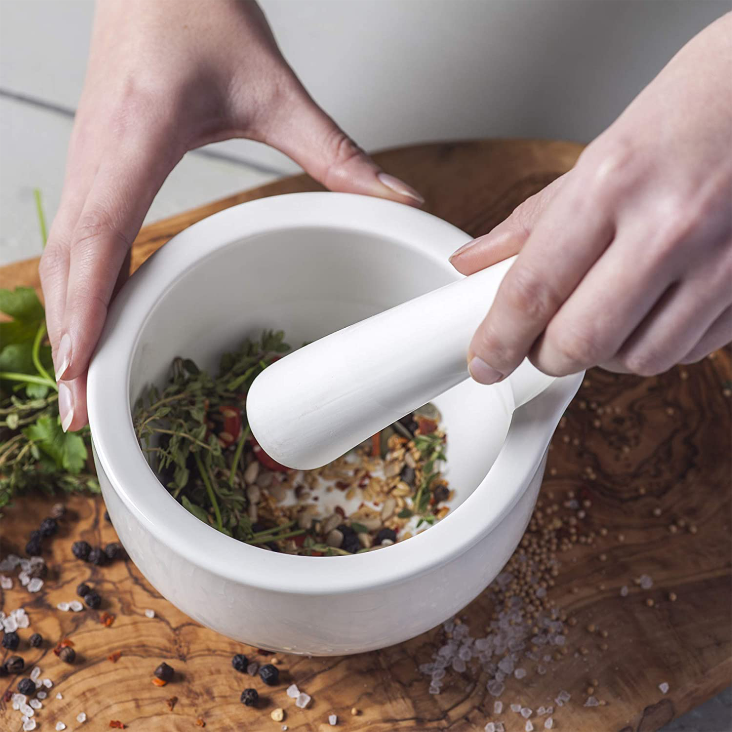 the and pestle being used to mash herbs and seeds