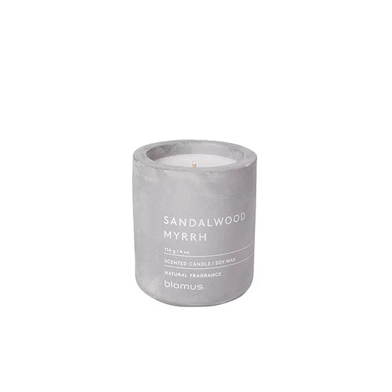 a sandalwood and Myrrh scented candle in a concrete container 