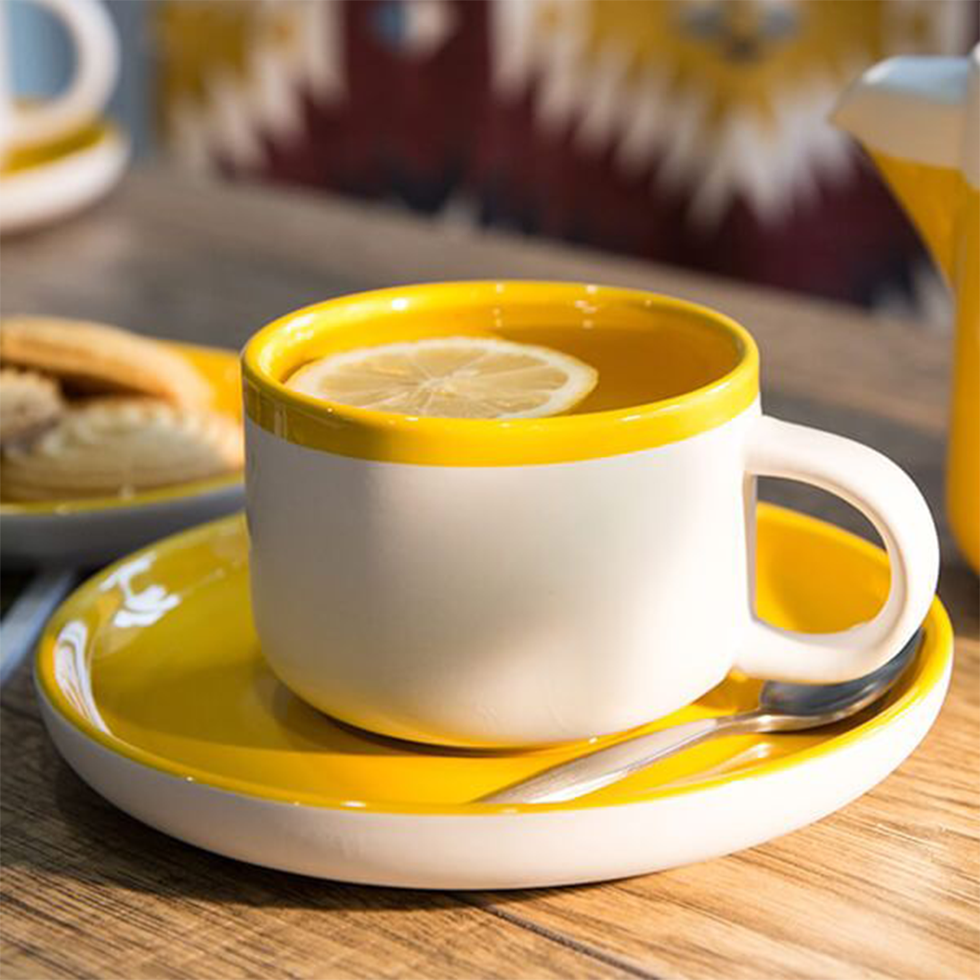 the tea cup and saucer displayed with the cup full of tea with a slice of lemon