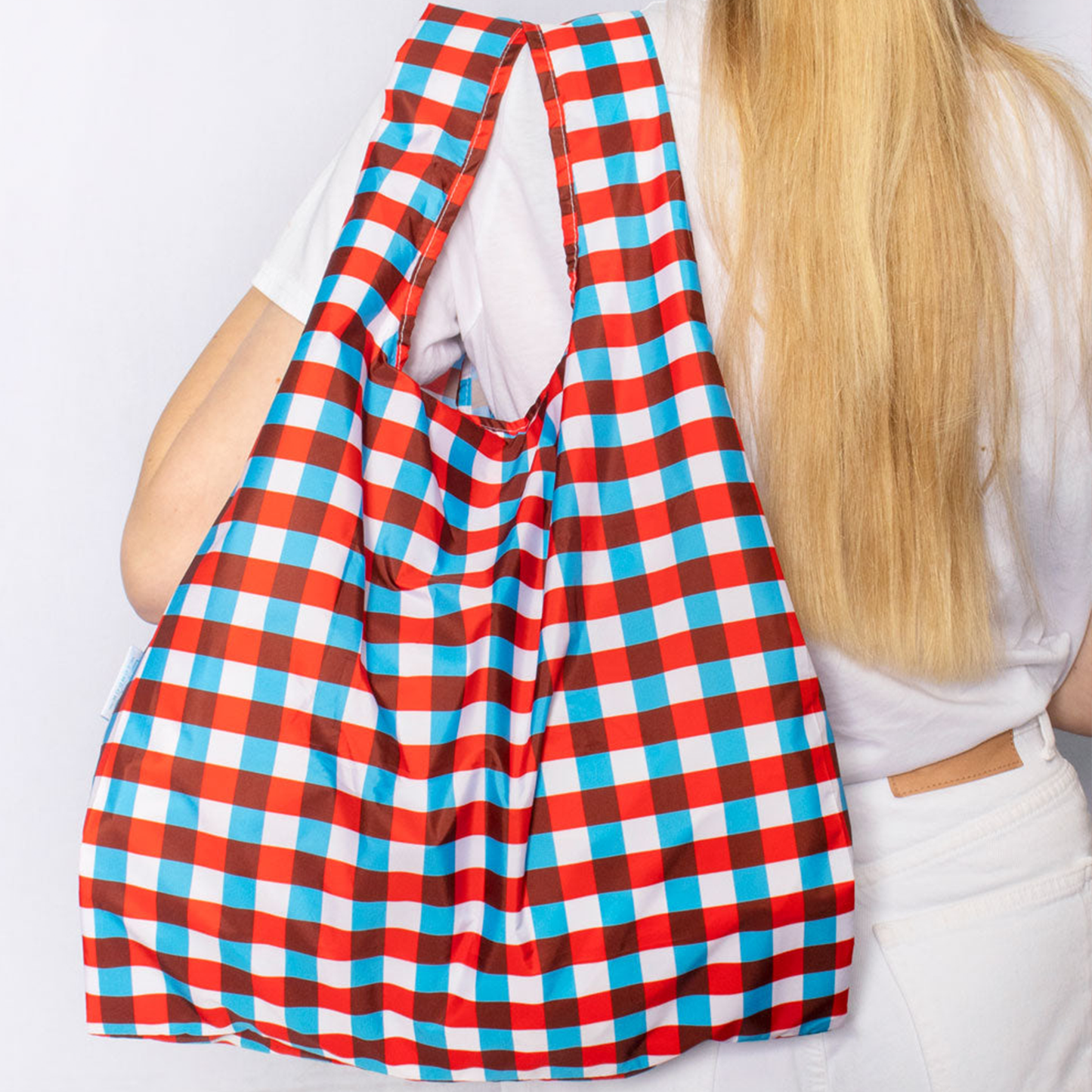 a woman holding the bag over her shoulder